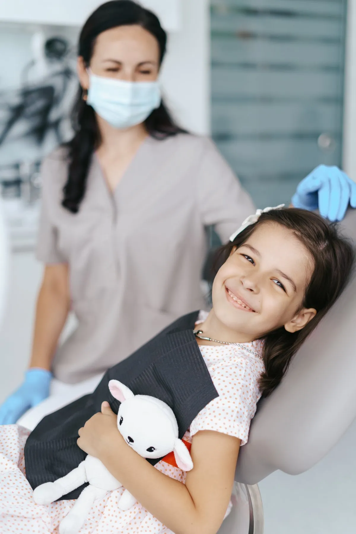 Niña sonriendo en el sillón dental